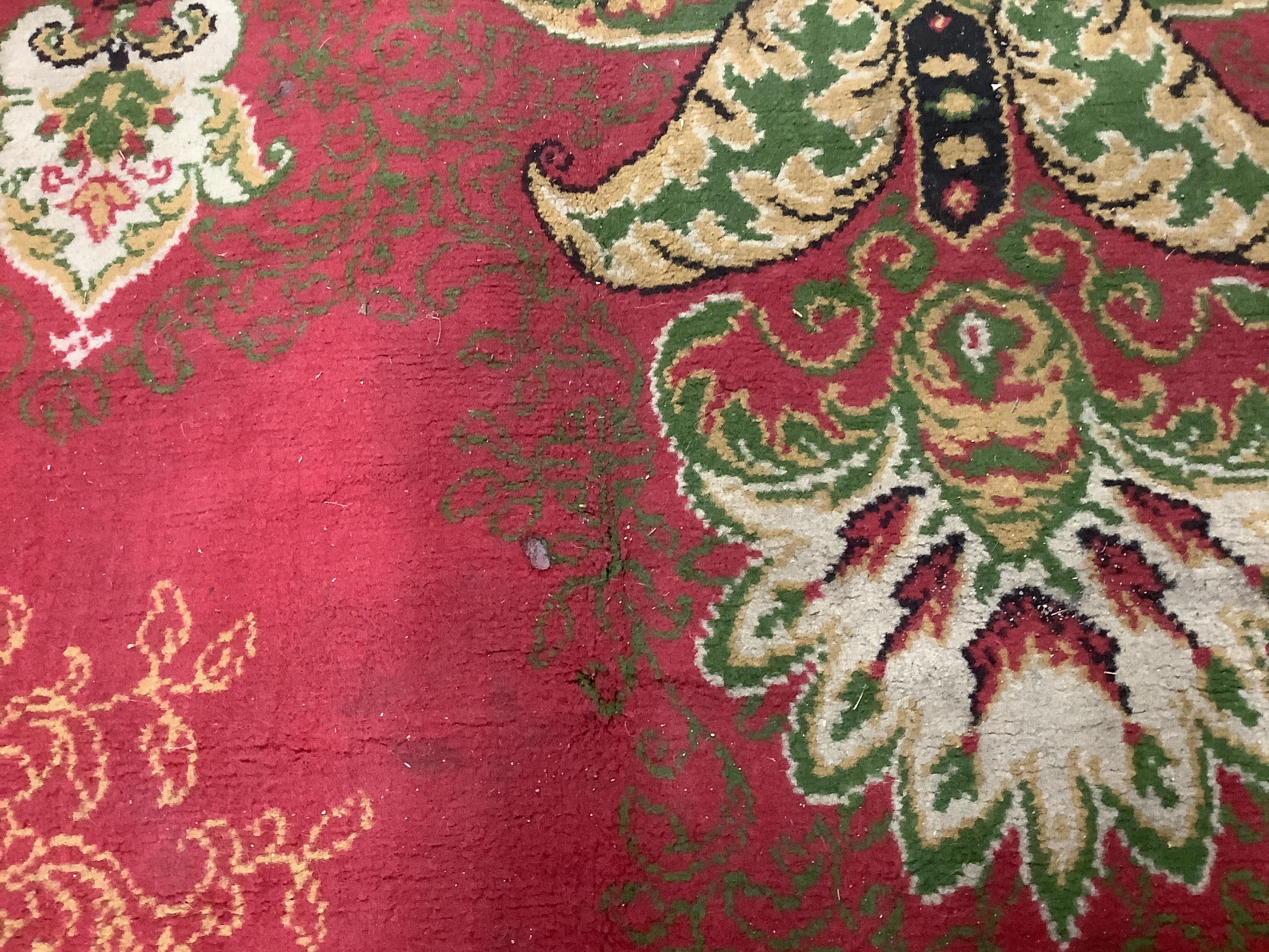 An Indian style machined red ground carpet, approx. 440 x 290cm